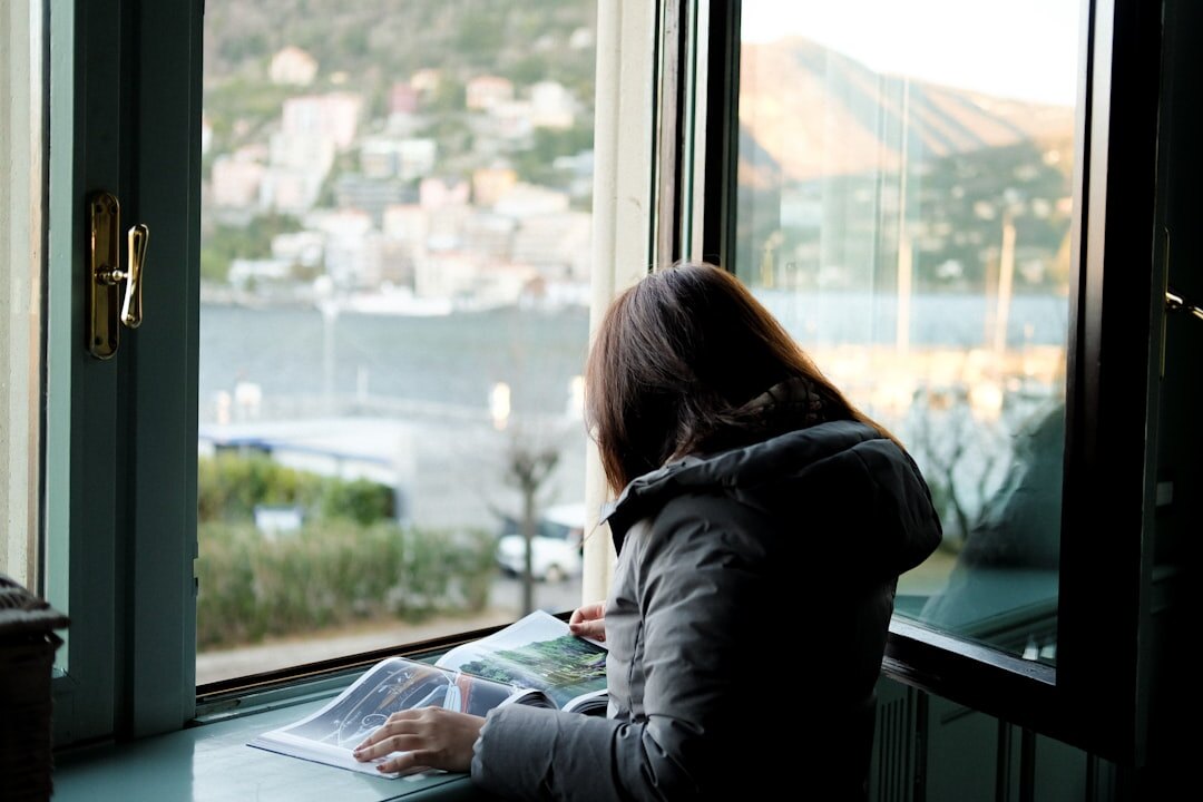 woman reading mystery book by window