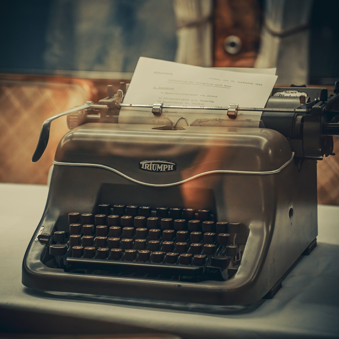 Vintage typewriter with a manuscript page under warm lamp light