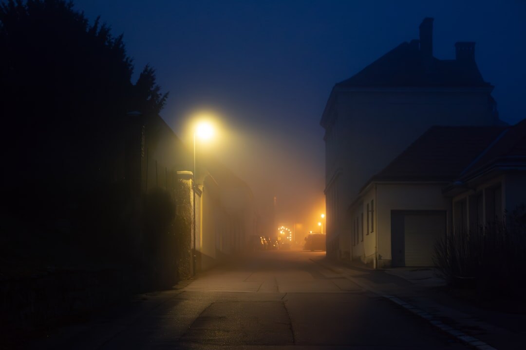 Foggy cobblestone street in an old European town at night